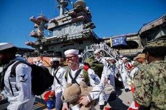 The USS Abraham Lincoln returns to California after 322 days deployed, including 265 consecutive days at sea, amid reports of shortages and crew hardship